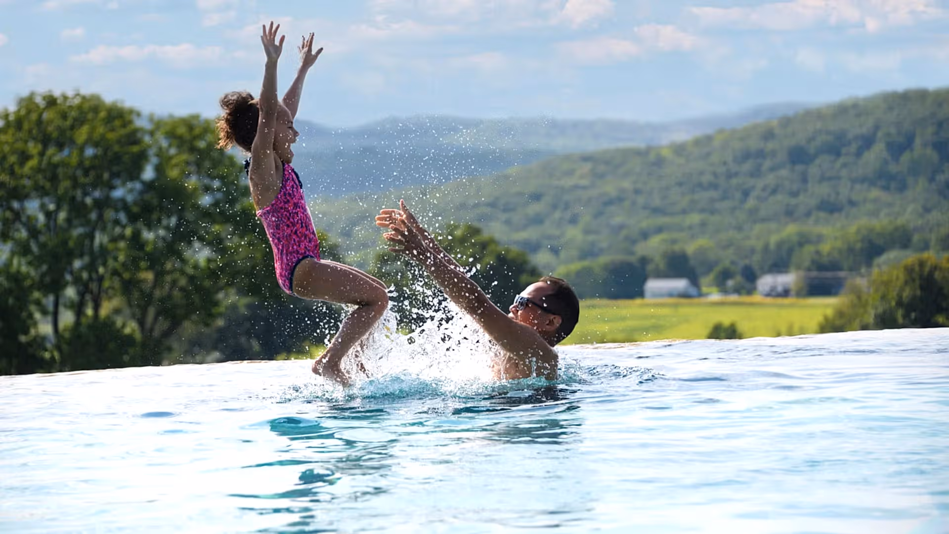 Man throws child in air in Vista pool.